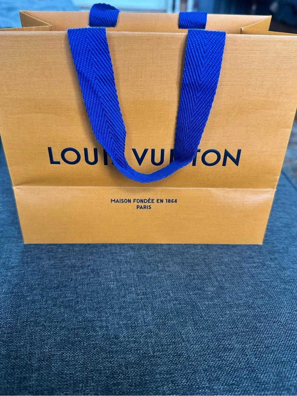 Louis Vuitton Orange Shopping Bag with Blue Handles and Black Logo